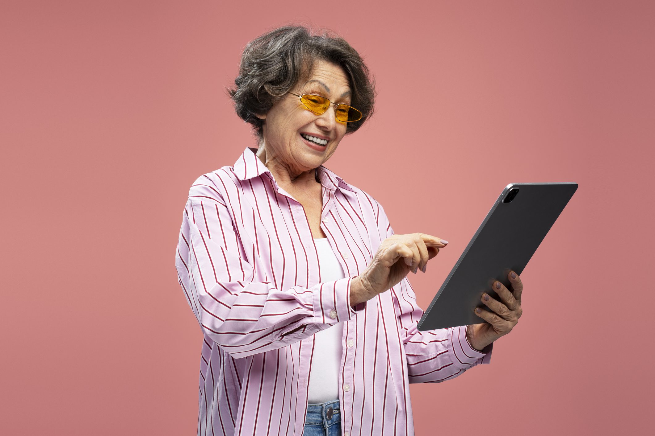 Excited senior woman holding a tablet Excited senior woman holding a tablet
