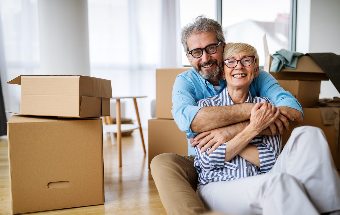 Portrait of happy senior couple in love moving in new home Smiling older couple moving into a new apartment.