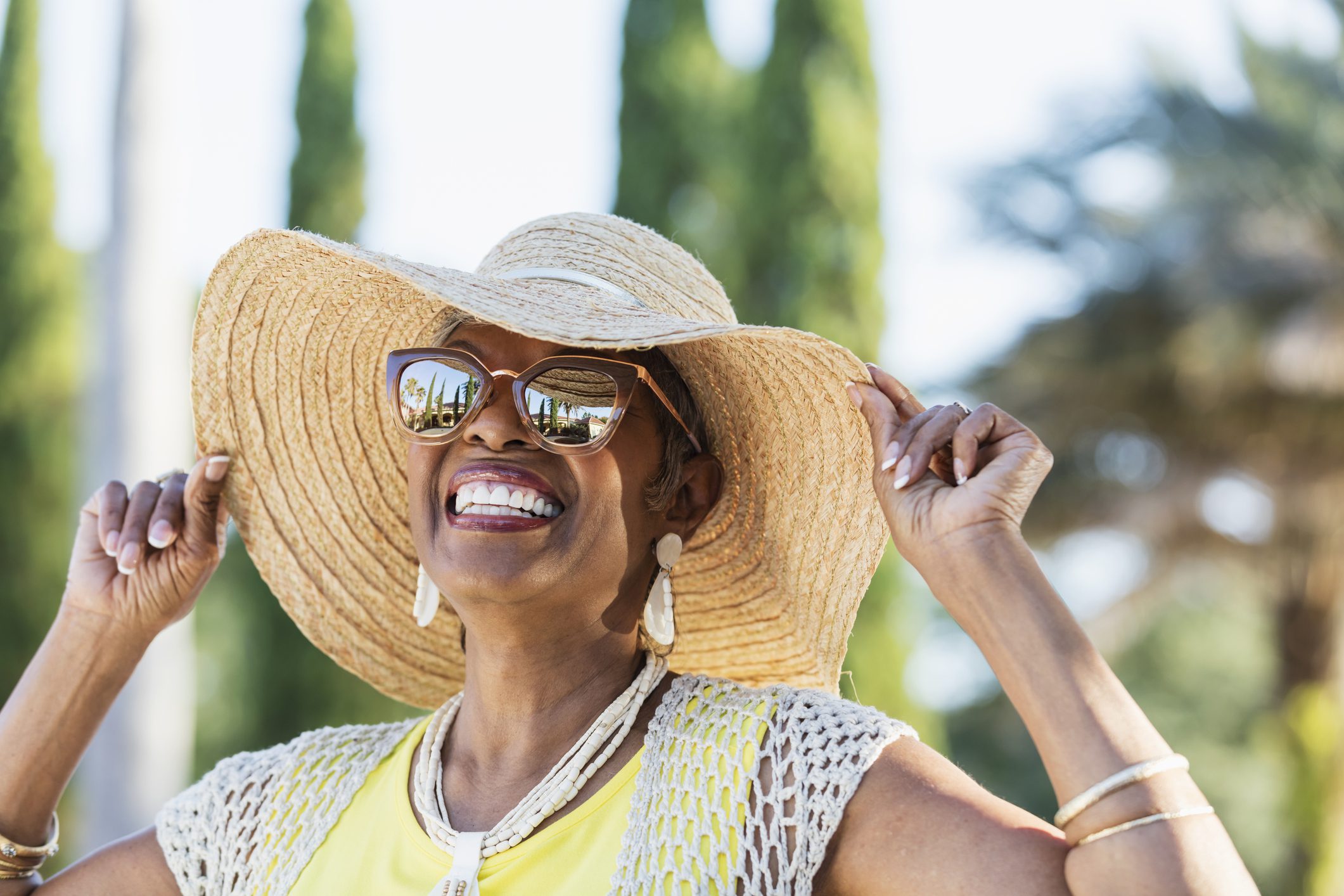 Smiling older woman in hat and sunglasses