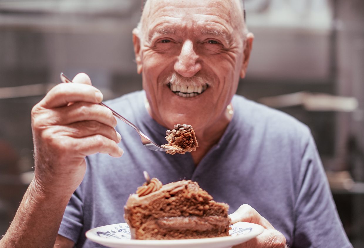 Older man eating pie and smiling at Prime Carolina Coast